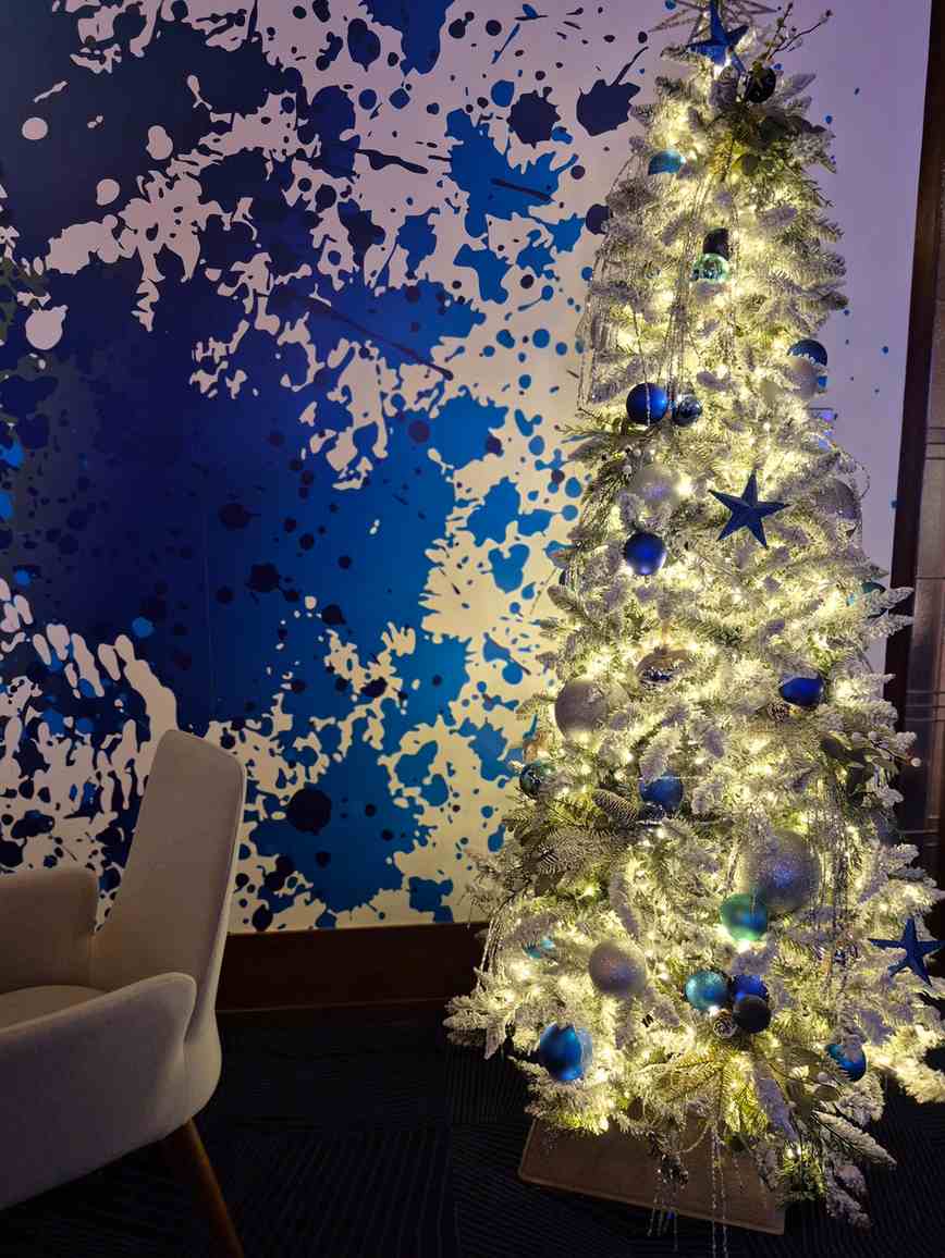 Sapin de Noël corporatif bleu et argent dans un espace de bureau